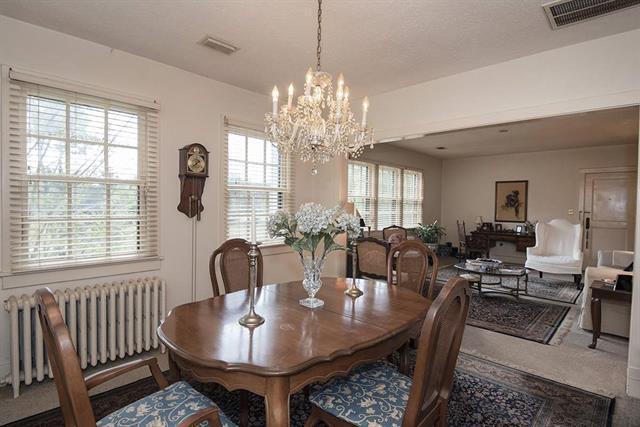 dining space with carpet flooring, radiator, and a notable chandelier