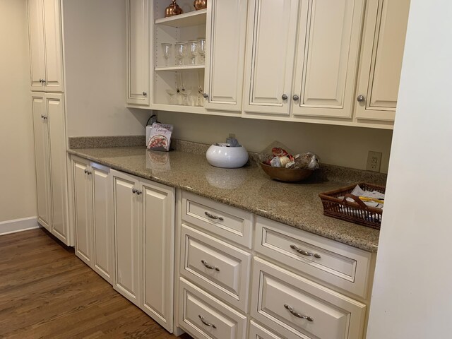 kitchen with dark wood-type flooring and light stone counters