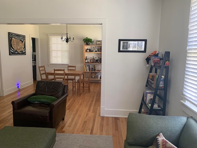 living room with light hardwood / wood-style floors, a chandelier, and plenty of natural light