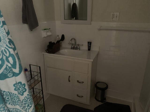 bathroom featuring vanity and tile walls