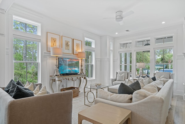 living room featuring a healthy amount of sunlight, light hardwood / wood-style floors, and ceiling fan