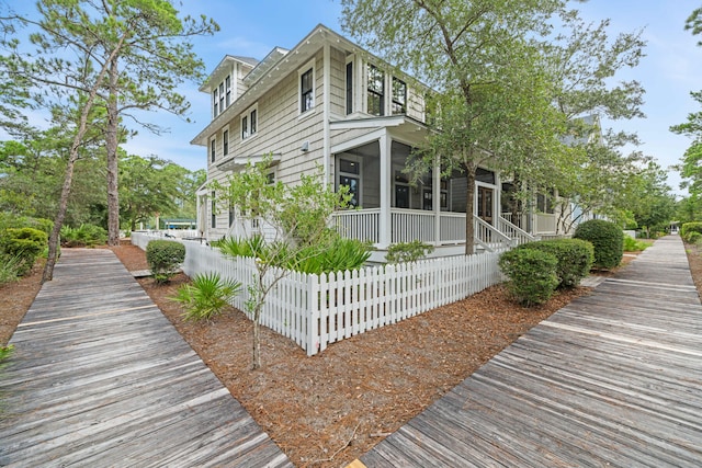 view of property exterior with a sunroom