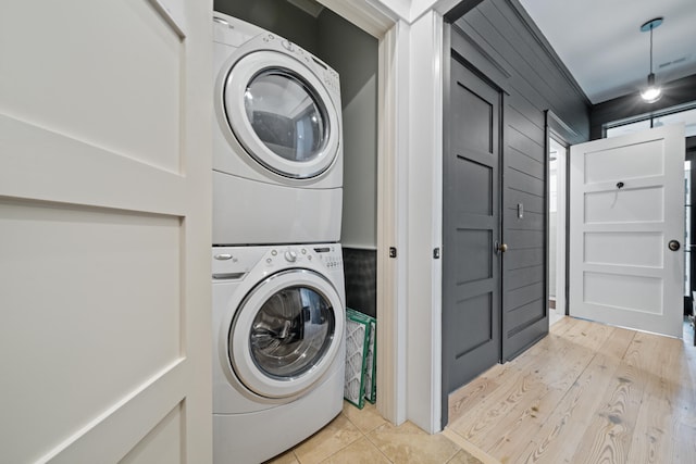 washroom with stacked washer / dryer and light hardwood / wood-style floors