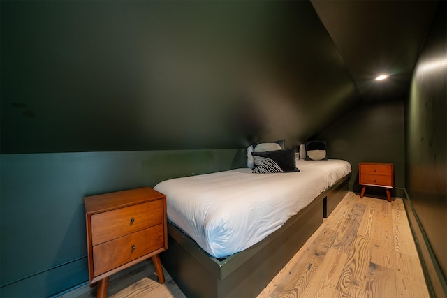 bedroom with lofted ceiling and light wood-type flooring