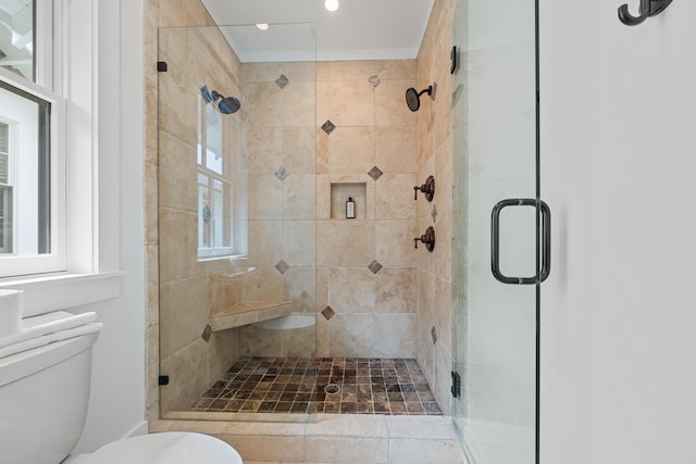 bathroom with a shower with door and toilet