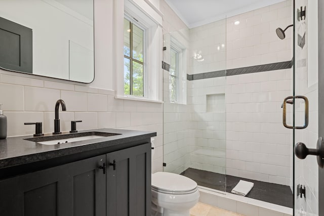 bathroom with vanity, tile walls, a shower with shower door, toilet, and tile patterned flooring