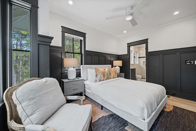 bedroom with hardwood / wood-style flooring, ensuite bath, and ceiling fan