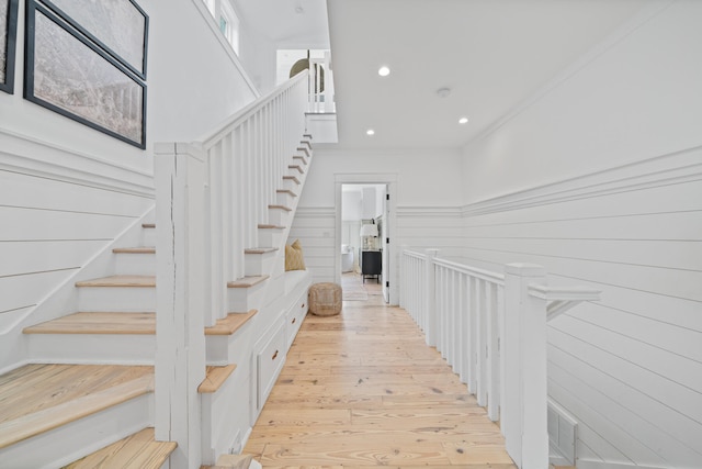 stairs with a high ceiling and light wood-type flooring