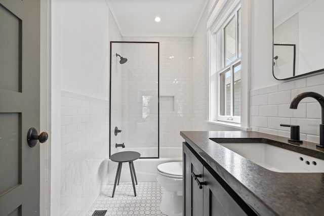 full bathroom with toilet, a healthy amount of sunlight, tile patterned flooring, and tile walls