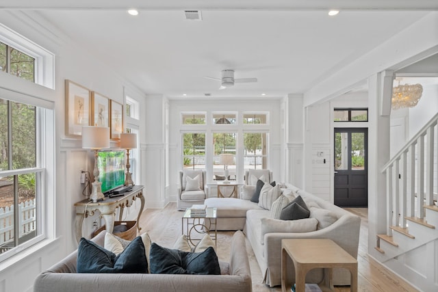 living room with light hardwood / wood-style flooring, a wealth of natural light, and ceiling fan