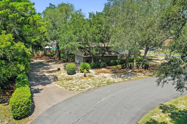 view of front of property featuring a garage, decorative driveway, and fence