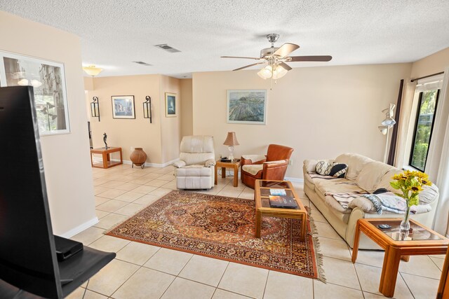 tiled living room with ceiling fan and a textured ceiling