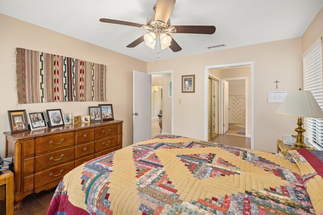 bedroom with ceiling fan, tile patterned flooring, and ensuite bathroom