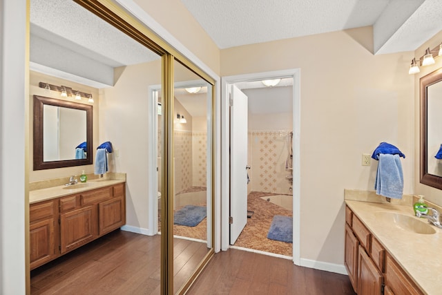 bathroom with hardwood / wood-style floors, a textured ceiling, and vanity