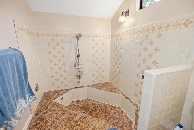 bathroom featuring tile patterned flooring and a tile shower