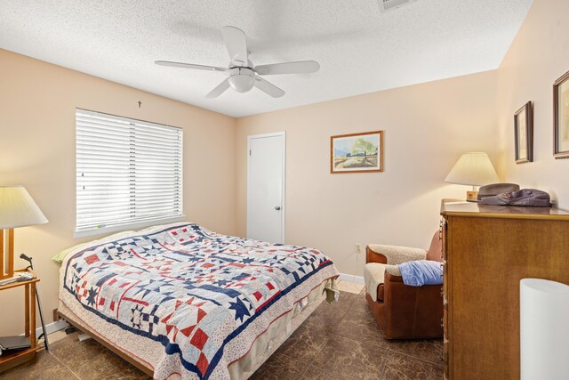 tiled bedroom with a textured ceiling and ceiling fan