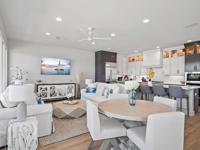 dining area with light hardwood / wood-style floors and ceiling fan