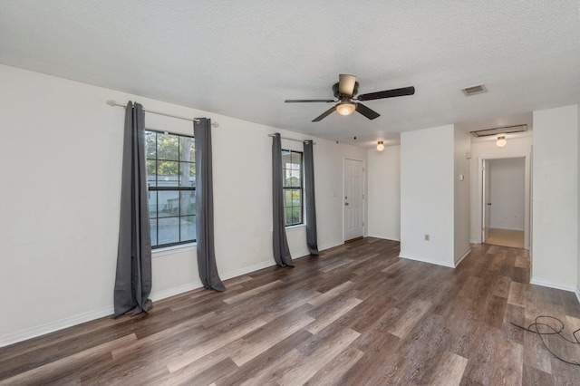 spare room with a textured ceiling, dark hardwood / wood-style flooring, and ceiling fan