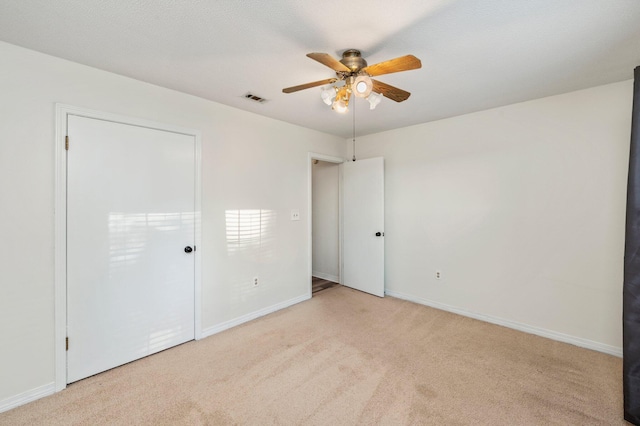 unfurnished bedroom featuring light carpet and ceiling fan