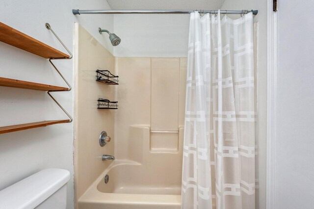 bathroom featuring shower / bath combo with shower curtain and toilet