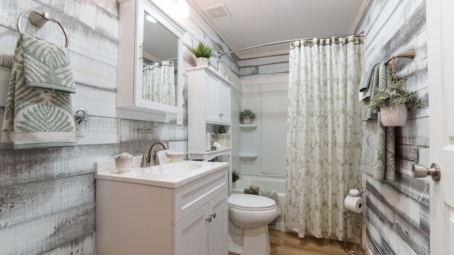 full bathroom with shower / tub combo, toilet, crown molding, hardwood / wood-style floors, and vanity