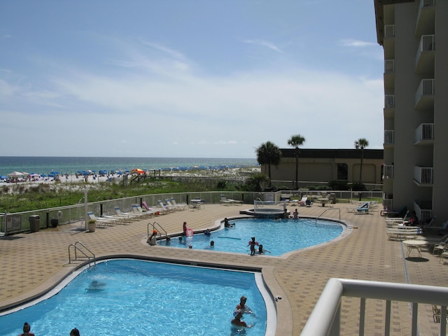 view of pool with a patio and a water view