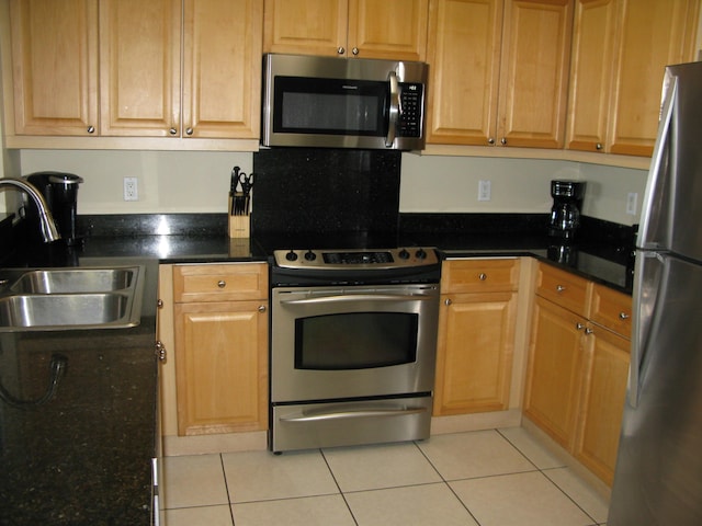 kitchen featuring light tile patterned flooring, stainless steel appliances, and sink