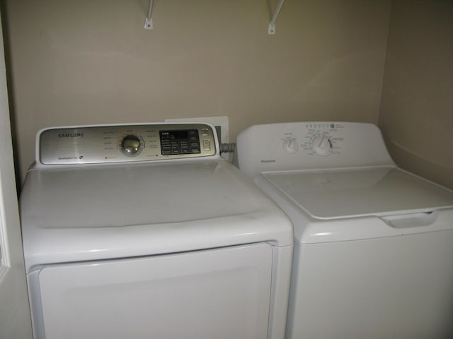 clothes washing area with washer and clothes dryer