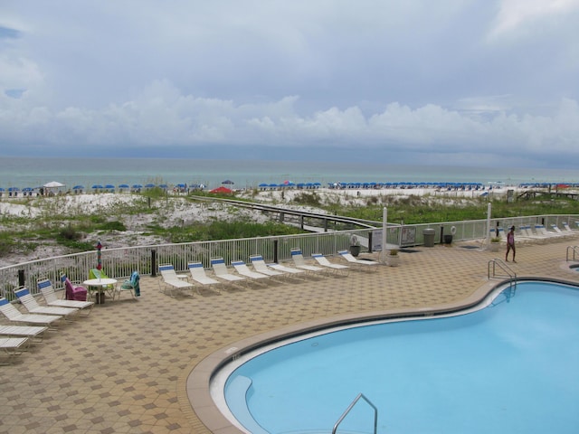 view of pool with a patio and a water view