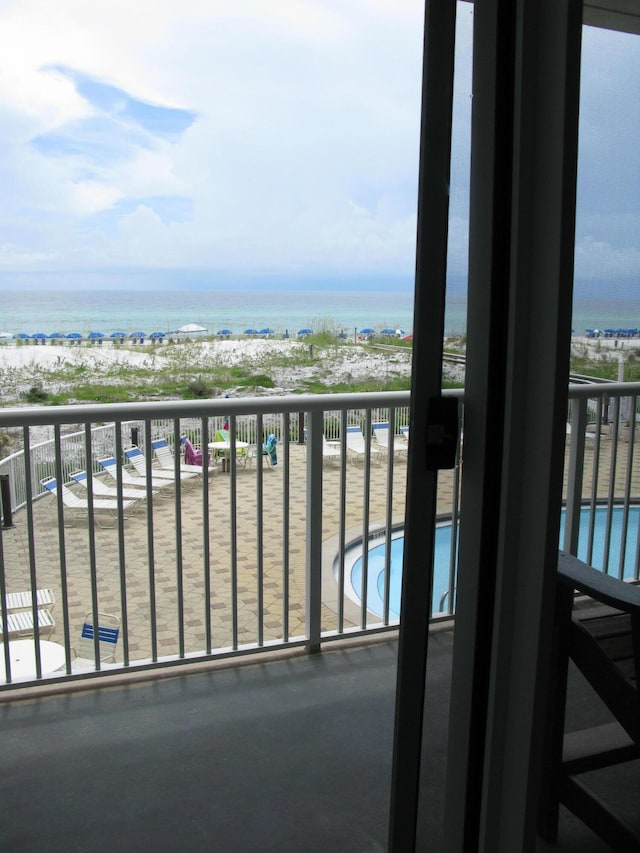 balcony with a water view and a beach view