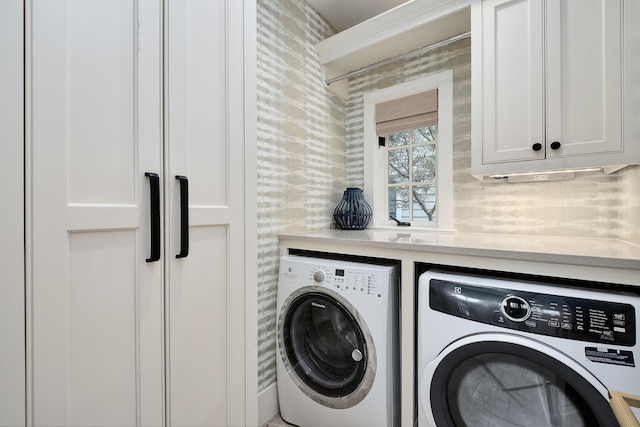 washroom featuring washer and dryer and cabinet space