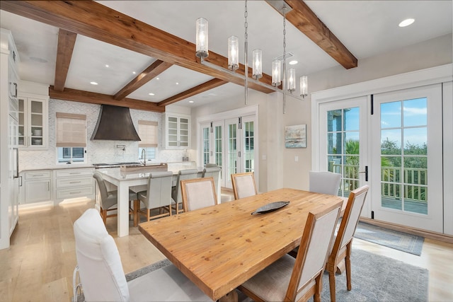 dining room with french doors, light wood-type flooring, and a healthy amount of sunlight