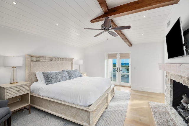 bedroom with access to outside, a high end fireplace, french doors, light wood-style floors, and vaulted ceiling with beams