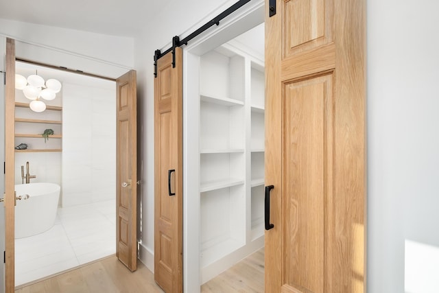 interior space with a barn door and light wood-style flooring