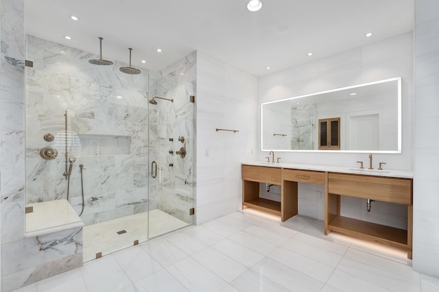 full bath featuring a marble finish shower, recessed lighting, double vanity, and a sink