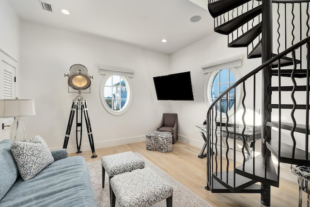 living room with light wood finished floors, visible vents, baseboards, stairway, and recessed lighting