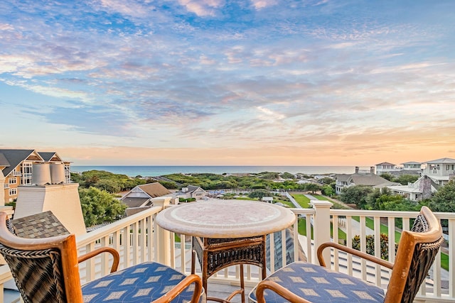 deck at dusk featuring a water view