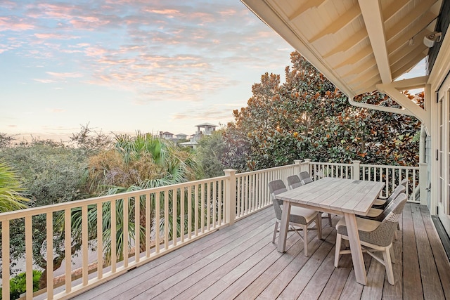 deck at dusk with outdoor dining space