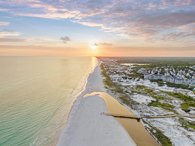 aerial view at dusk with a beach view and a water view