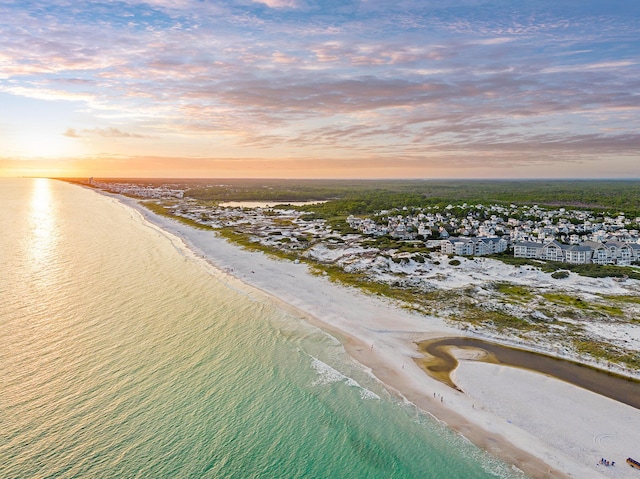 aerial view at dusk featuring a beach view and a water view