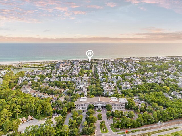 aerial view at dusk with a beach view and a water view