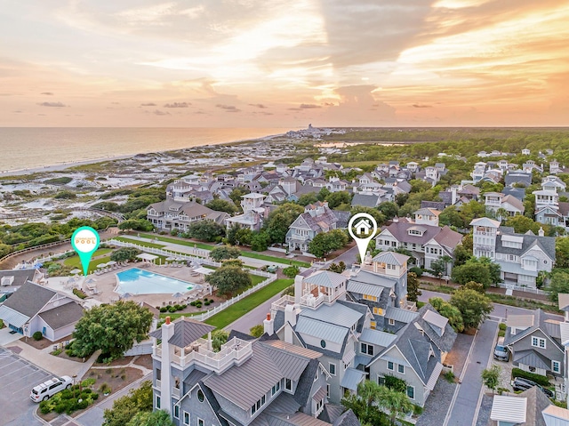 aerial view at dusk with a residential view and a water view