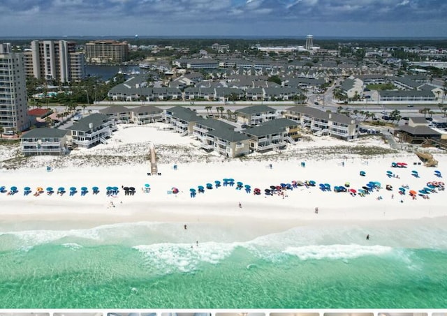 drone / aerial view featuring a view of the beach, a city view, and a water view