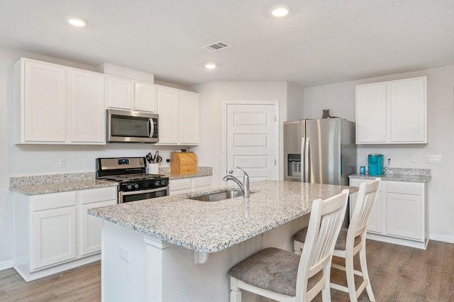 kitchen featuring a kitchen island with sink, light hardwood / wood-style floors, appliances with stainless steel finishes, and sink