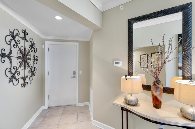 entrance foyer with crown molding and light tile patterned floors