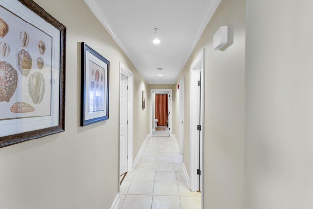 hall featuring light tile patterned flooring and crown molding