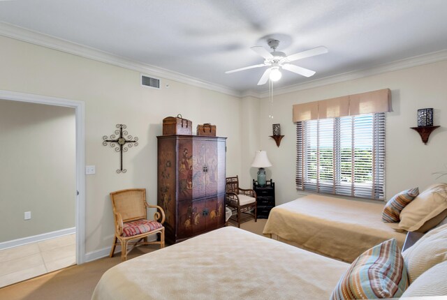 carpeted bedroom with ornamental molding and ceiling fan