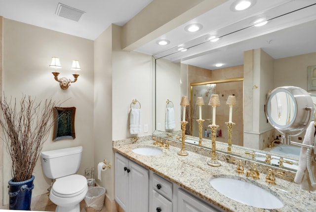 bathroom featuring vanity, a shower with shower door, and toilet