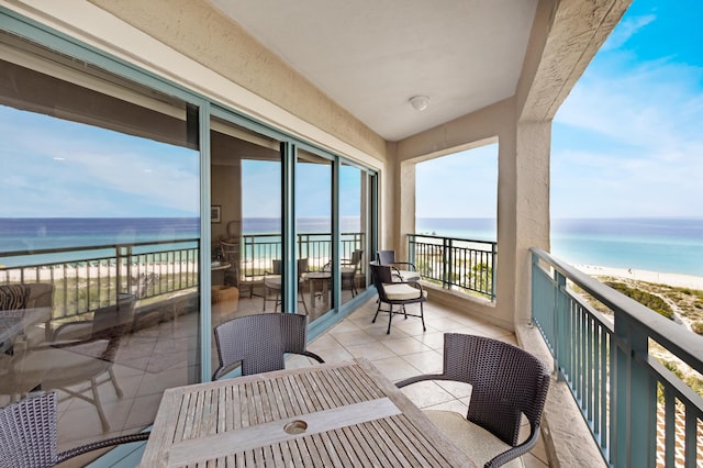 balcony with a water view and a beach view