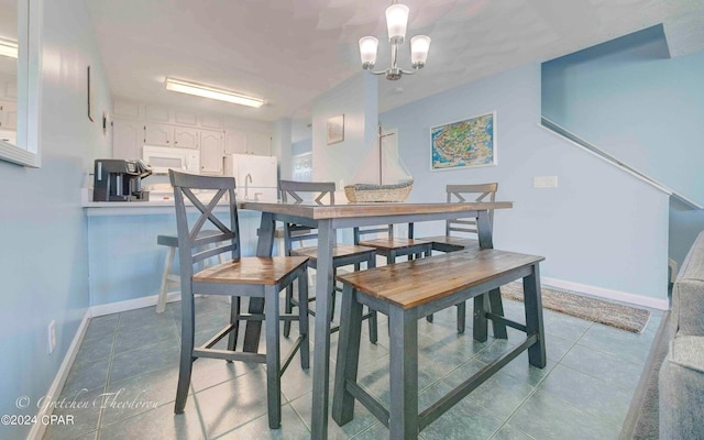 tiled dining room featuring a notable chandelier